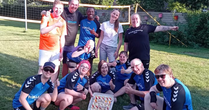 G-groep team in tuin met grote taart
